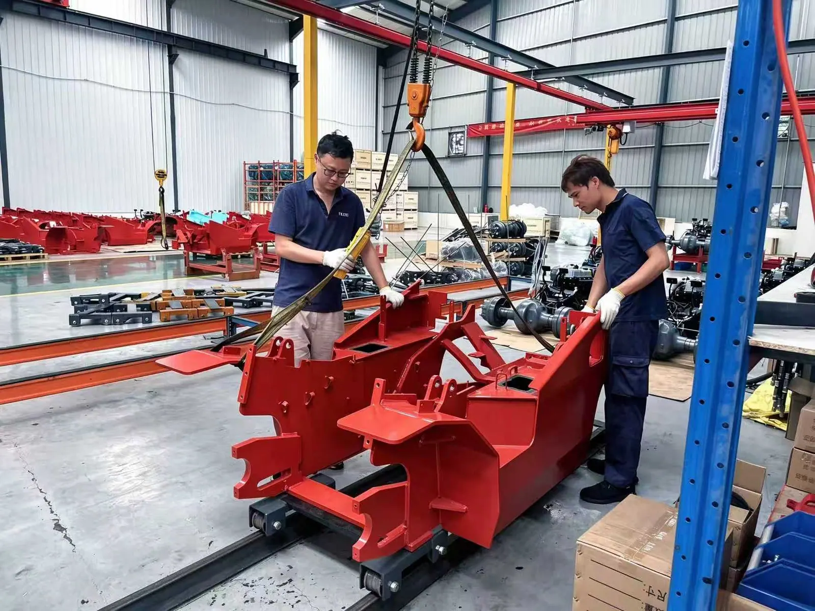 Two TLERA technicians assembling a machine frame in the workshop